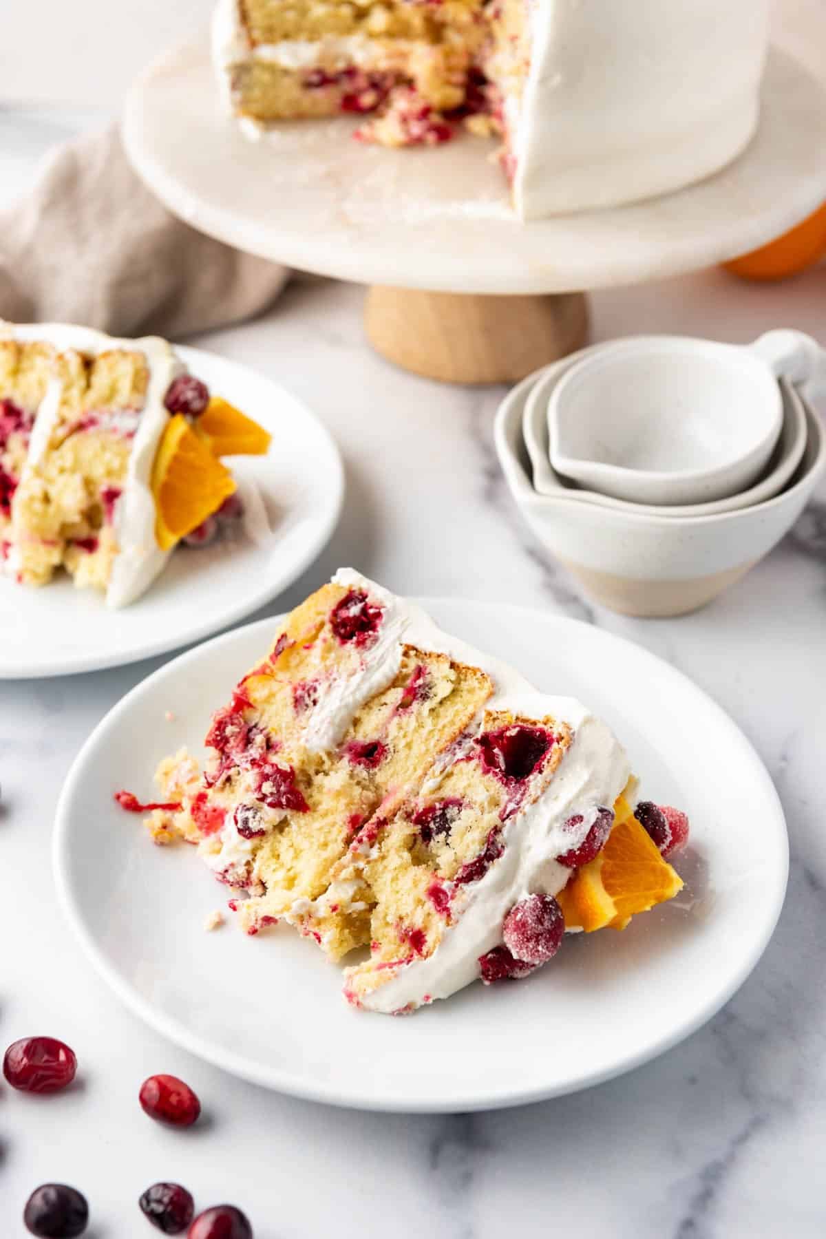 A slice of cranberry orange cake on a white plate.