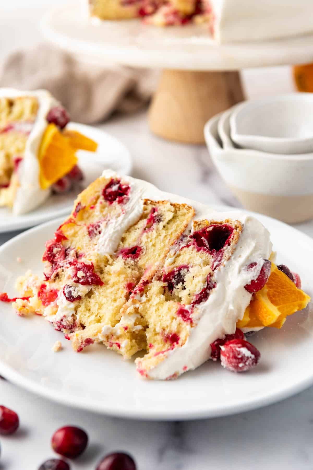 A slice of cranberry orange cake on a white plate.