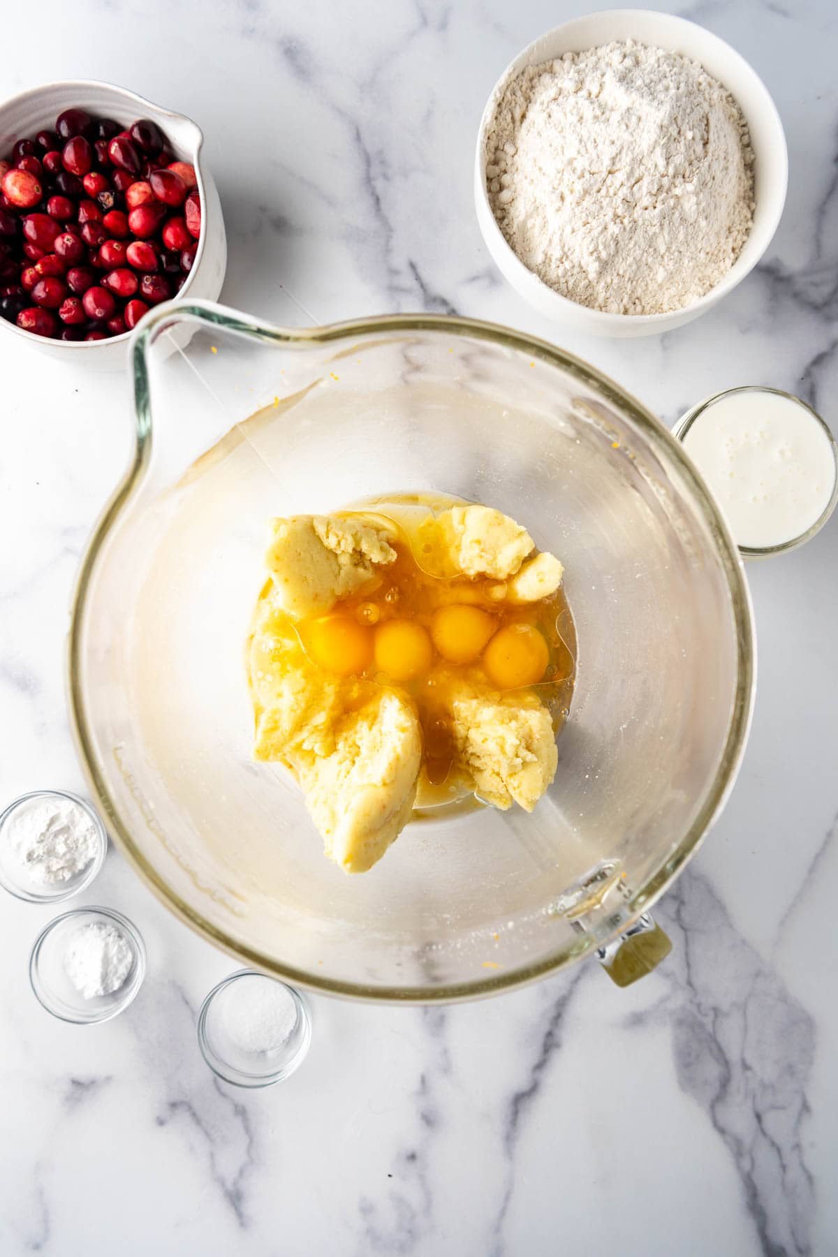 Adding eggs to creamed butter and sugar in a large mixing bowl.
