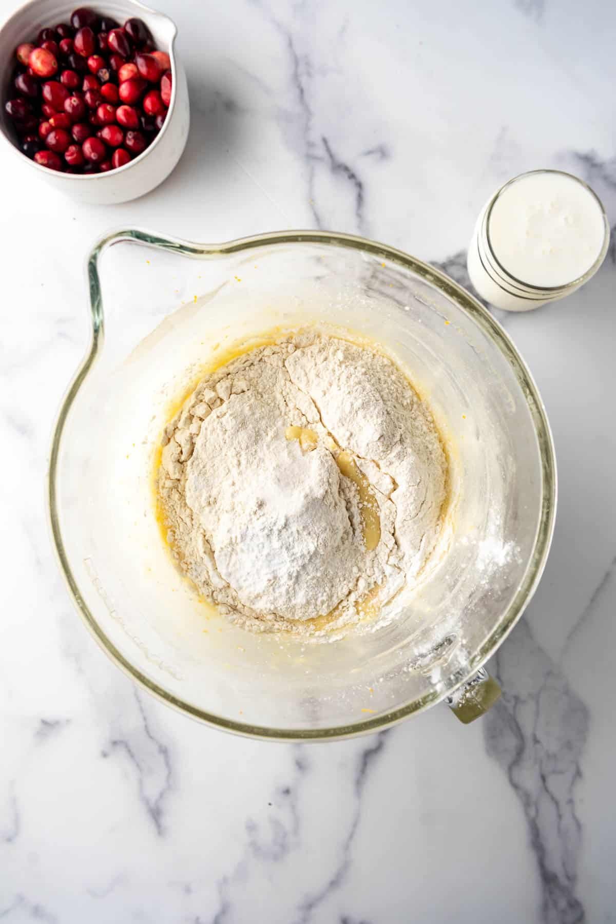 Adding dry ingredients to wet ingredients in a large bowl.
