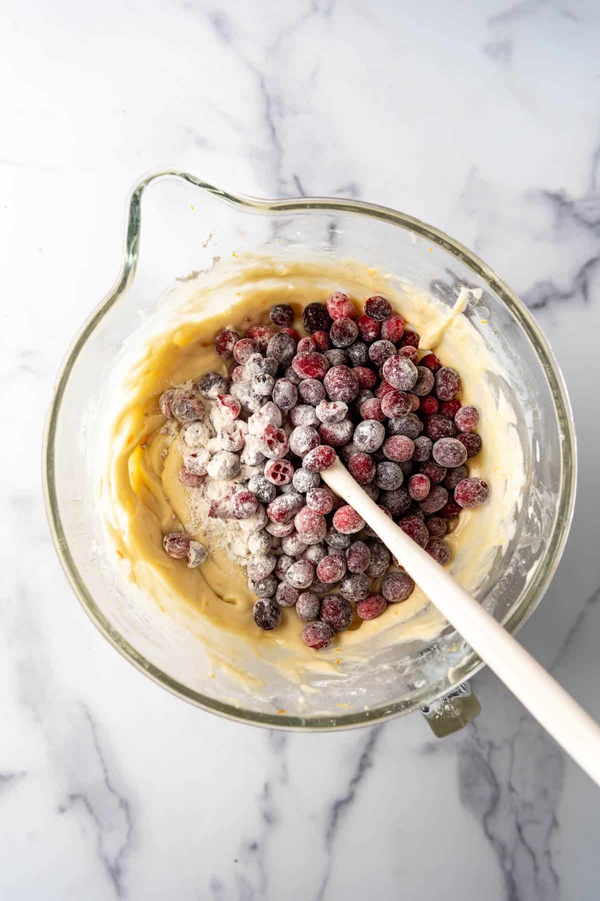 Folding cranberries that have been tossed in flour into cake batter.