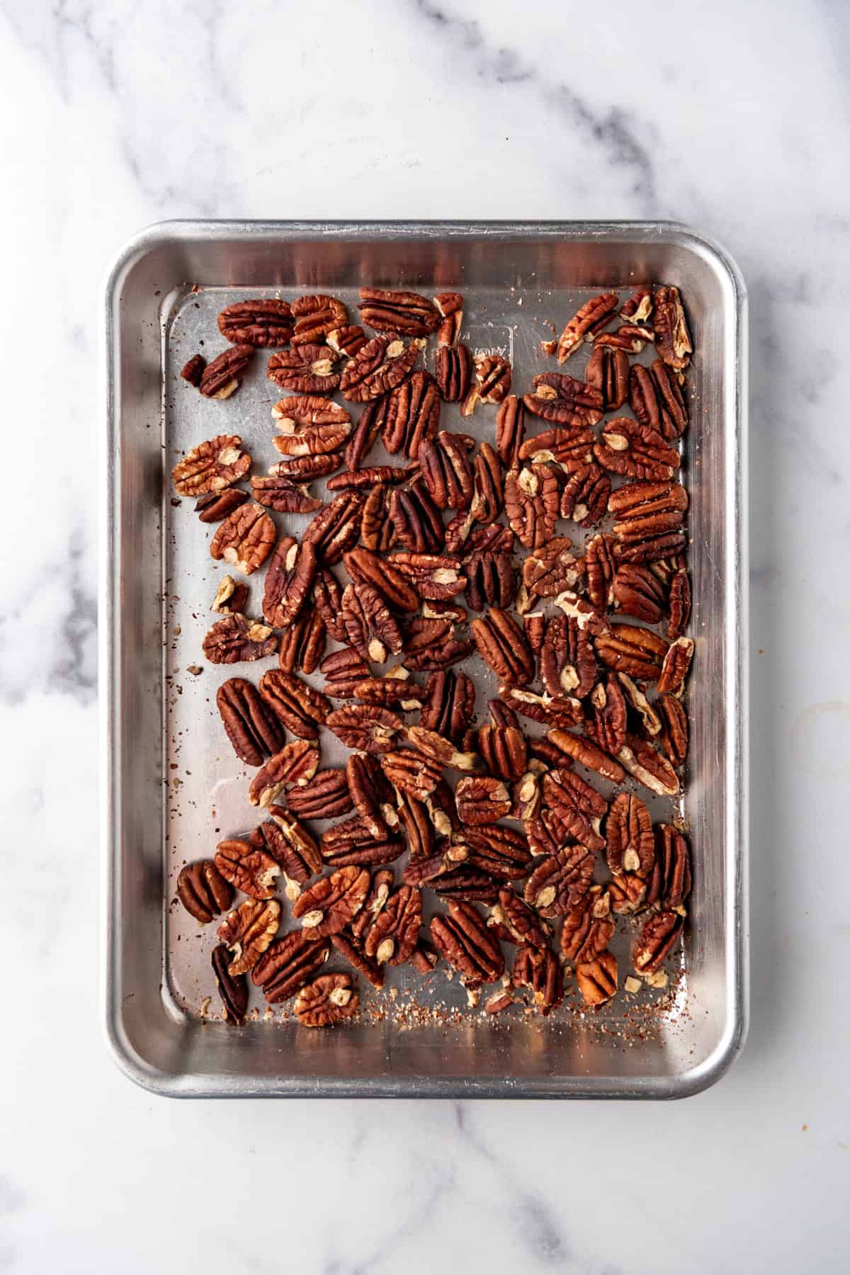 An image of toasted pecans on a baking sheet.