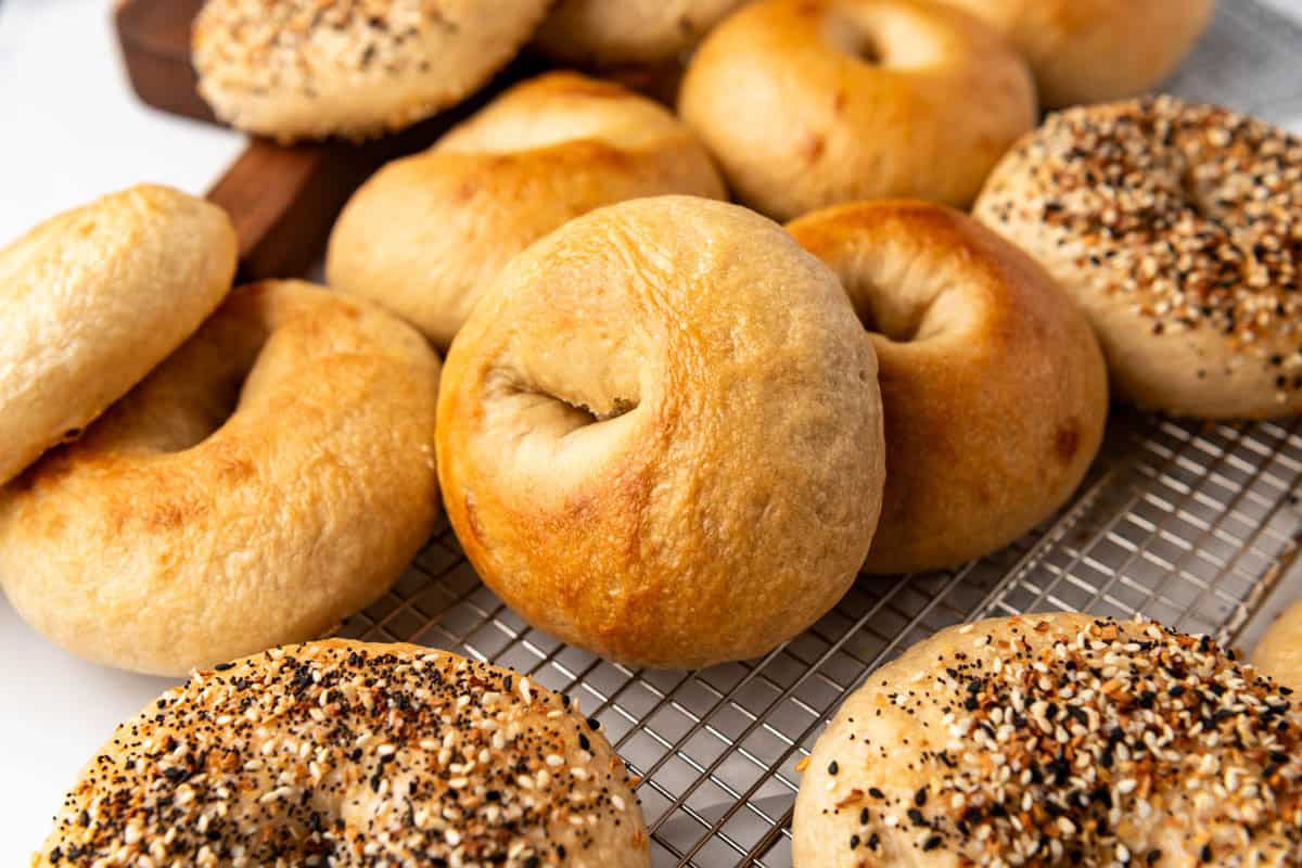 Bagels leaning on each other on a wire rack.