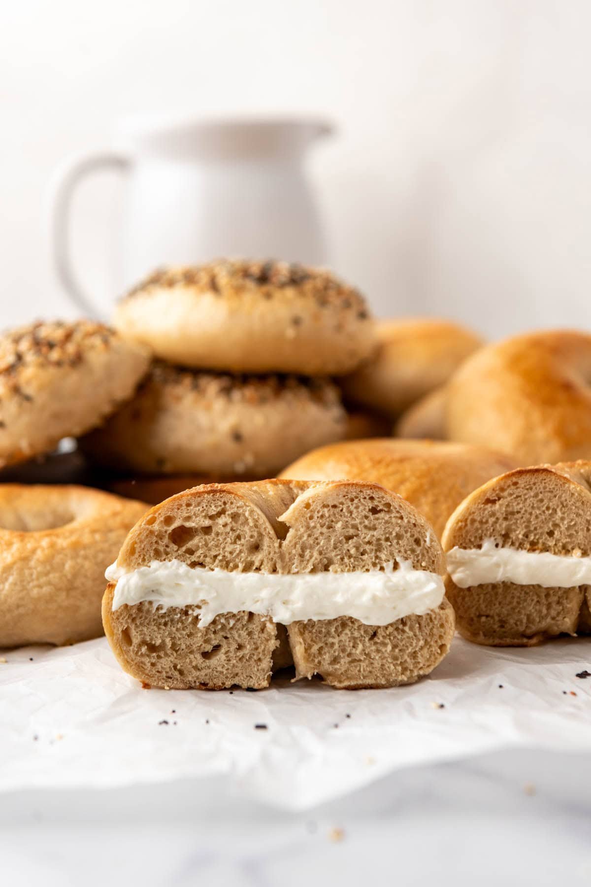 A sliced and toasted bagel with cream cheese in the middle.
