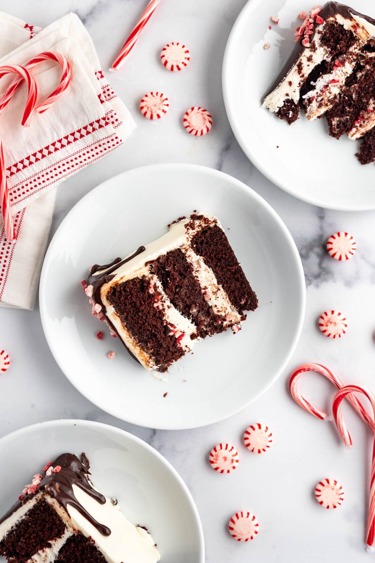 An overhead image of a slice of peppermint bark cake on a white plate.