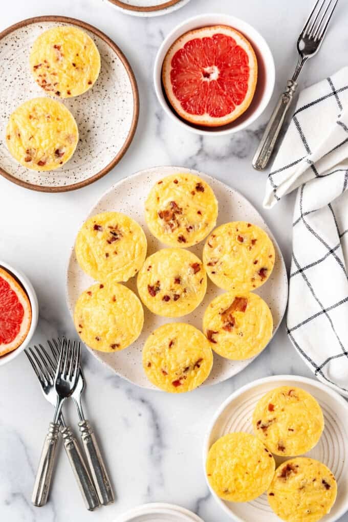An overhead image of copycat starbucks egg bites o n a plate with grapefruit halves around it.