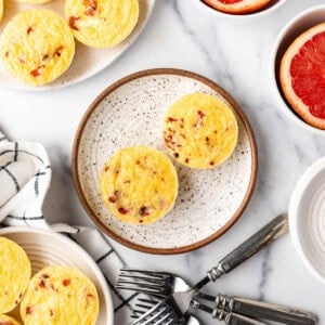 An overhead image of copycat starbucks egg bites on a plate with grapefruit halves around it.
