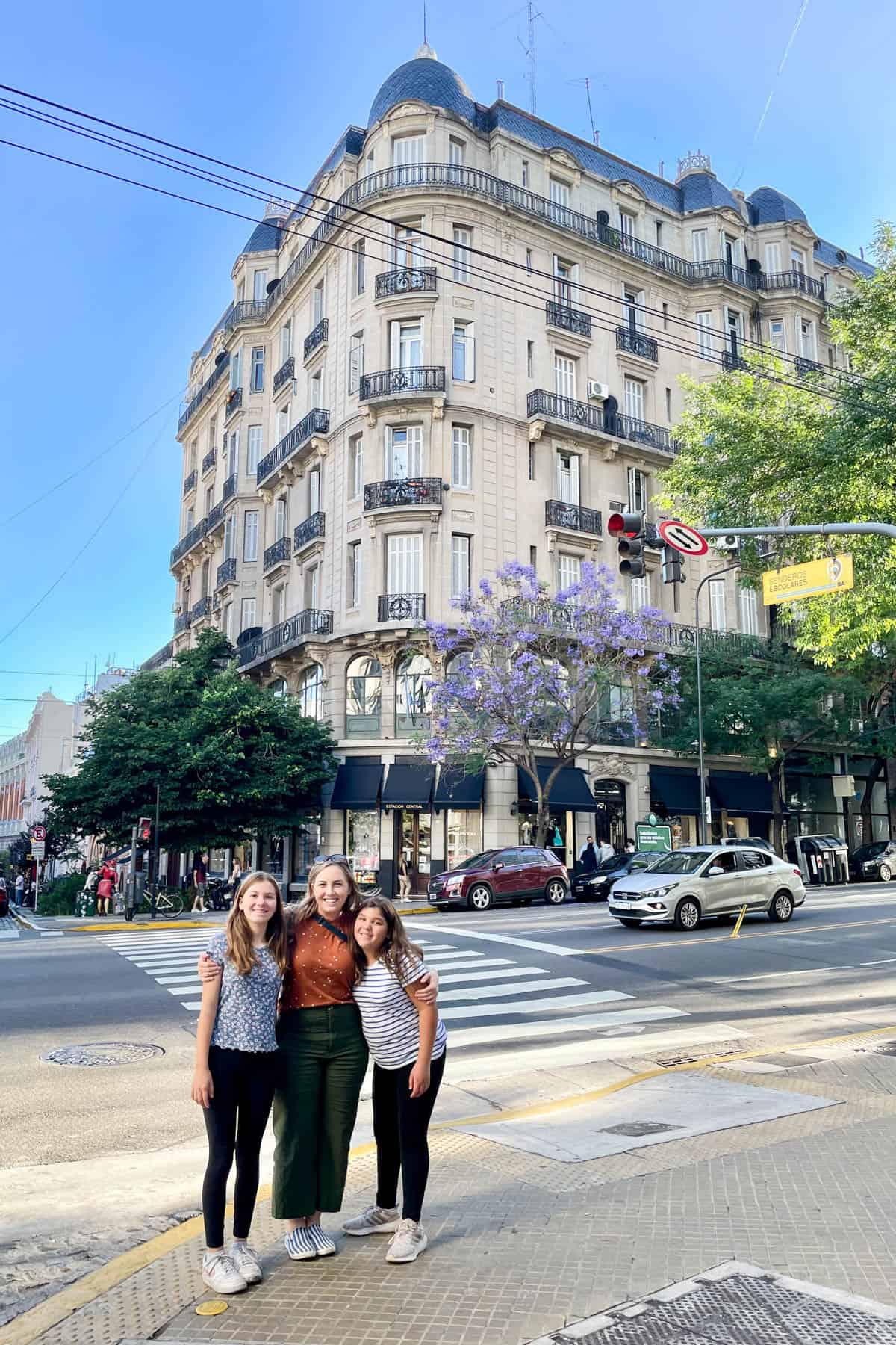 A mom and two daughters on a street corner in Buenos Aires.
