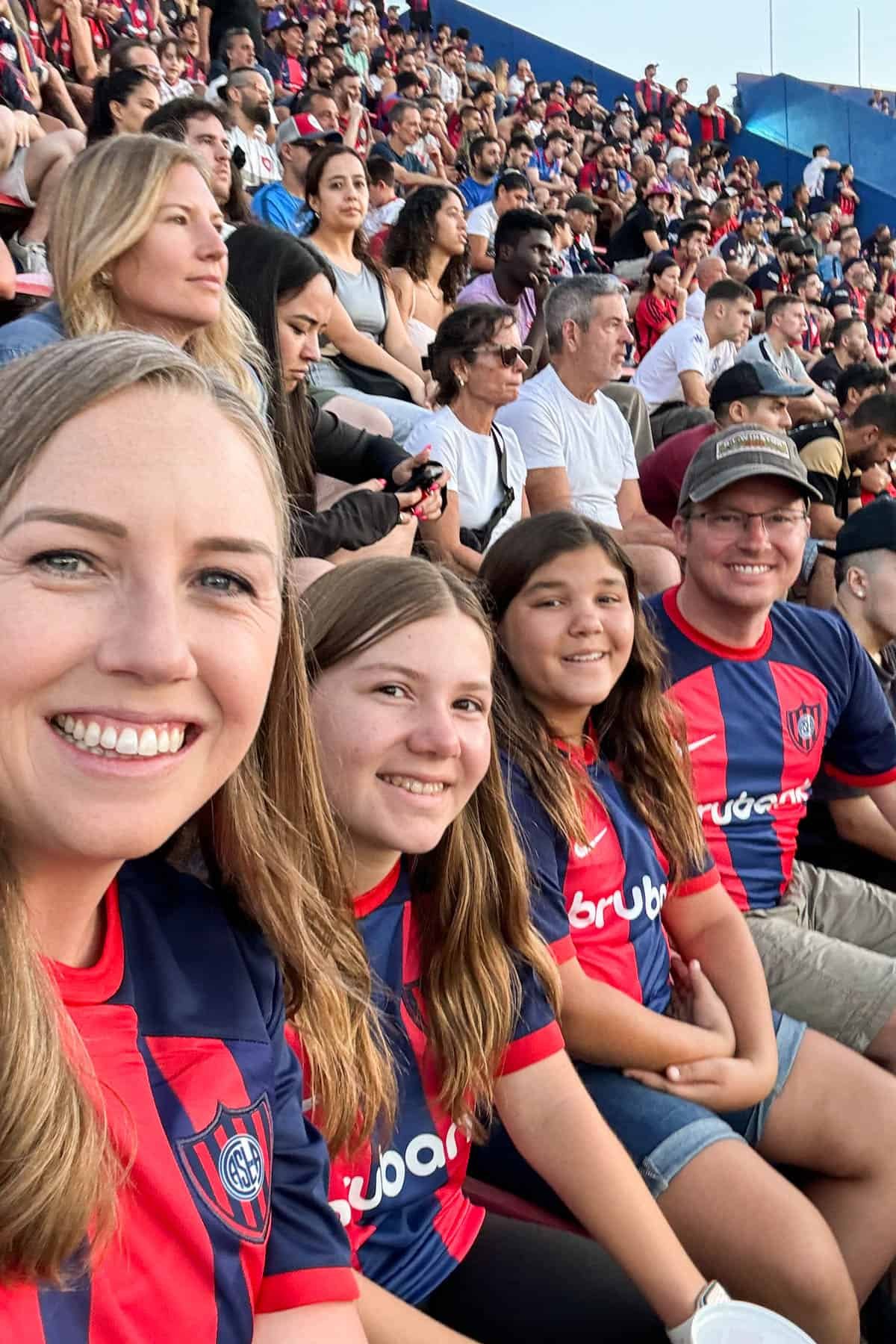 A family in soccer jerseys waiting for a soccer match to start in Buenos Aires.