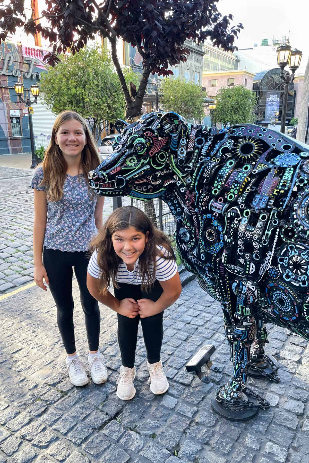 Kids next to street art in Buenos Aires.