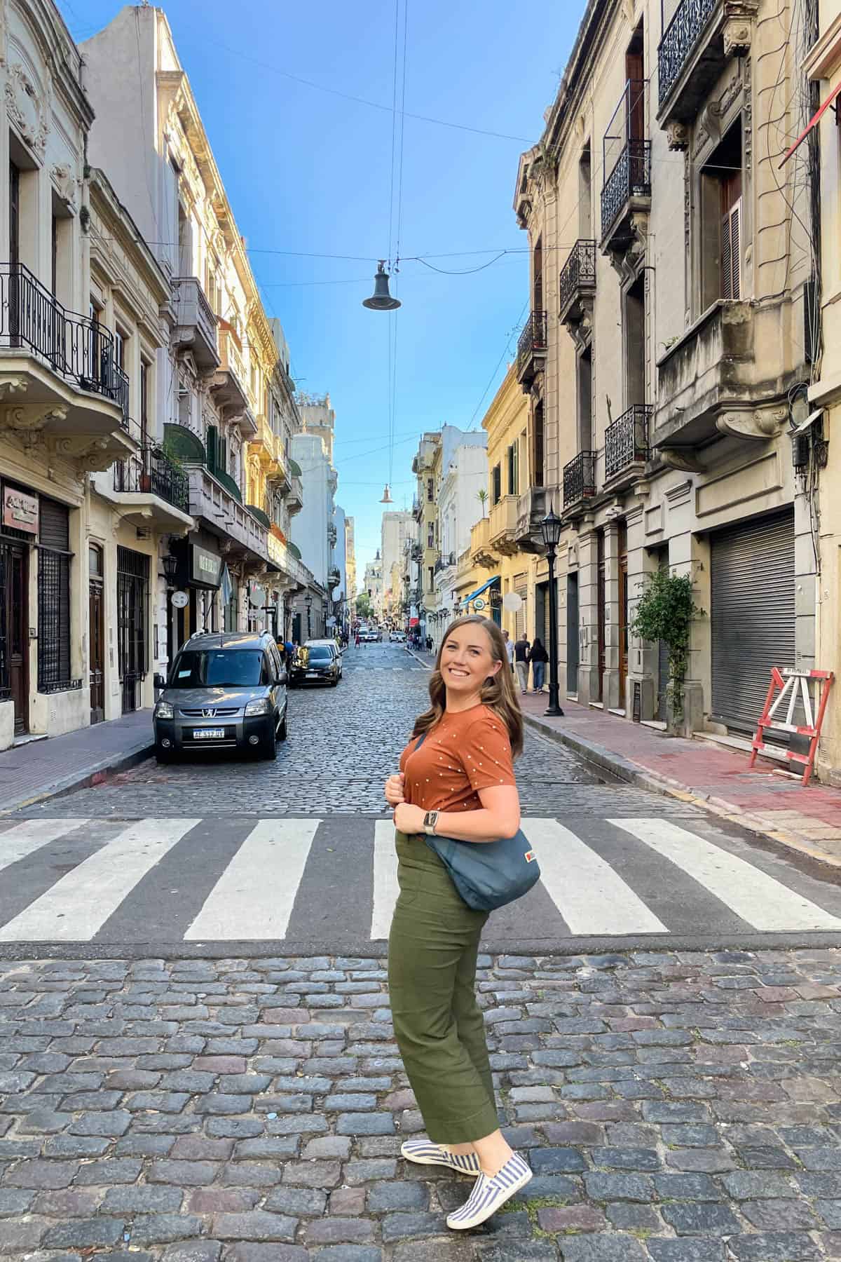 A woman walking on cobblestone streets in Buenos Aires.