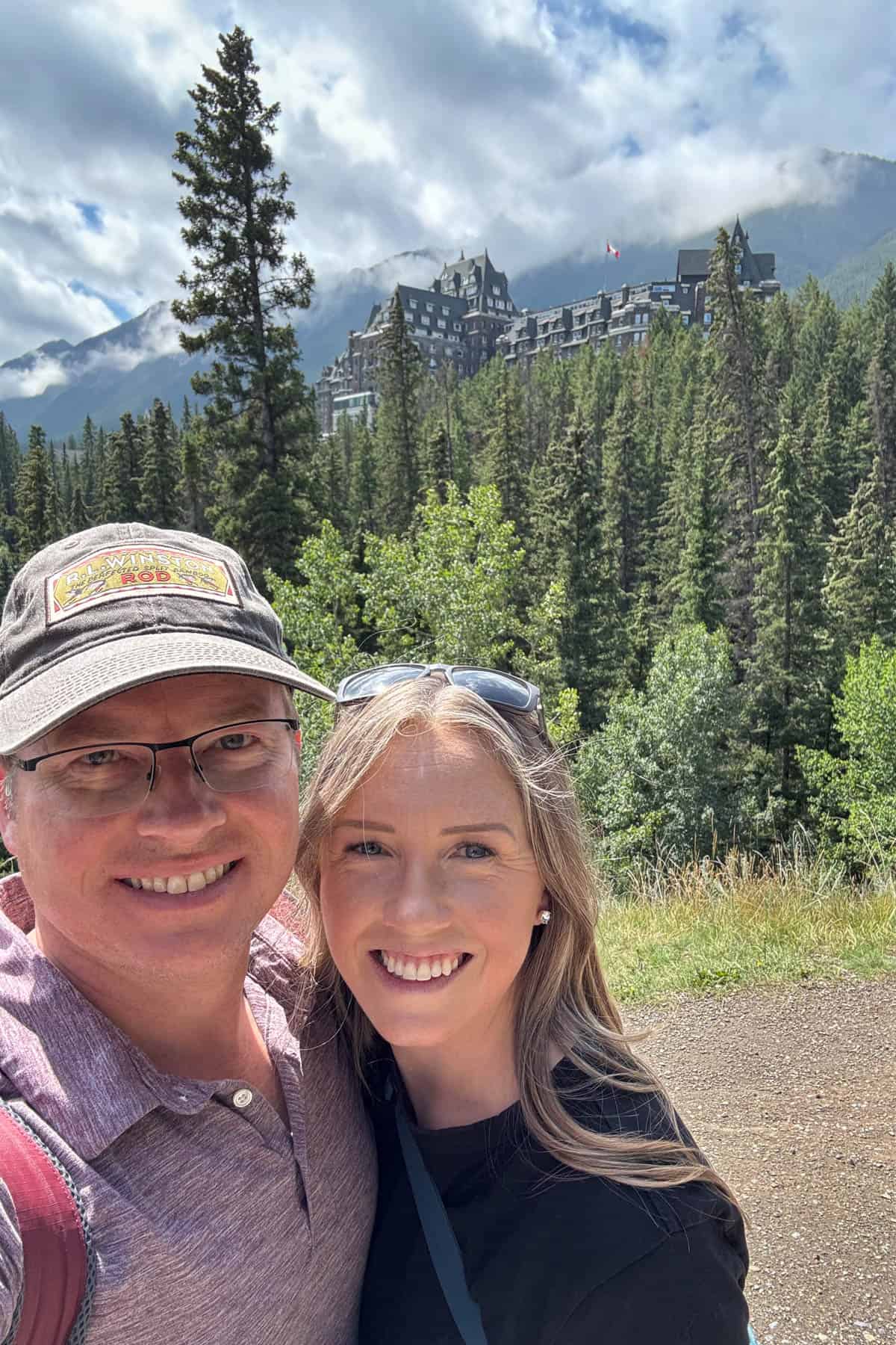 A couple posing for a selfie in front of the Fairmont Banff Springs Hotel.