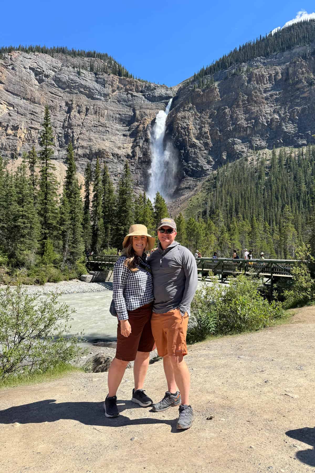 A husband and wife in front of Takakkaw Falls in Canada.