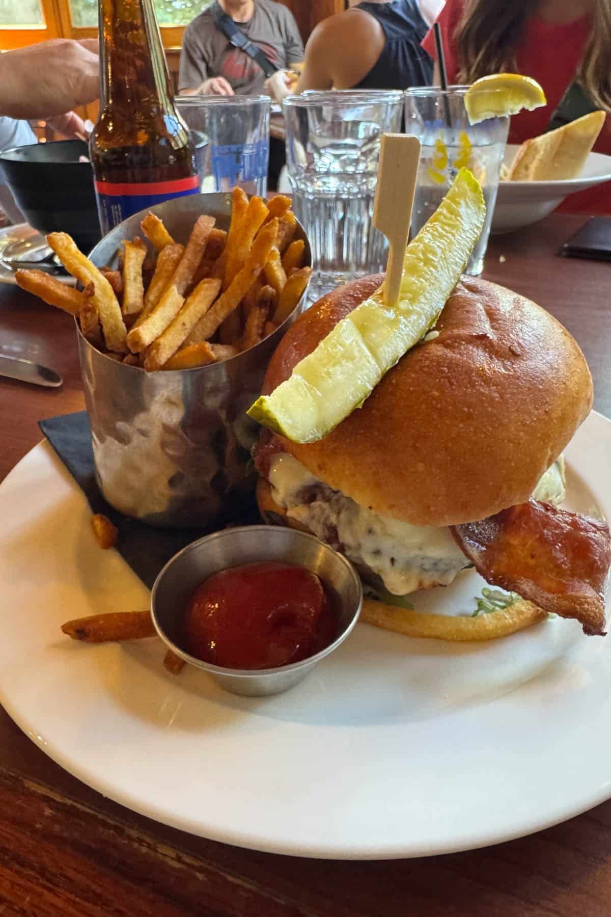 A burger and fries on a plate at a restaurant.
