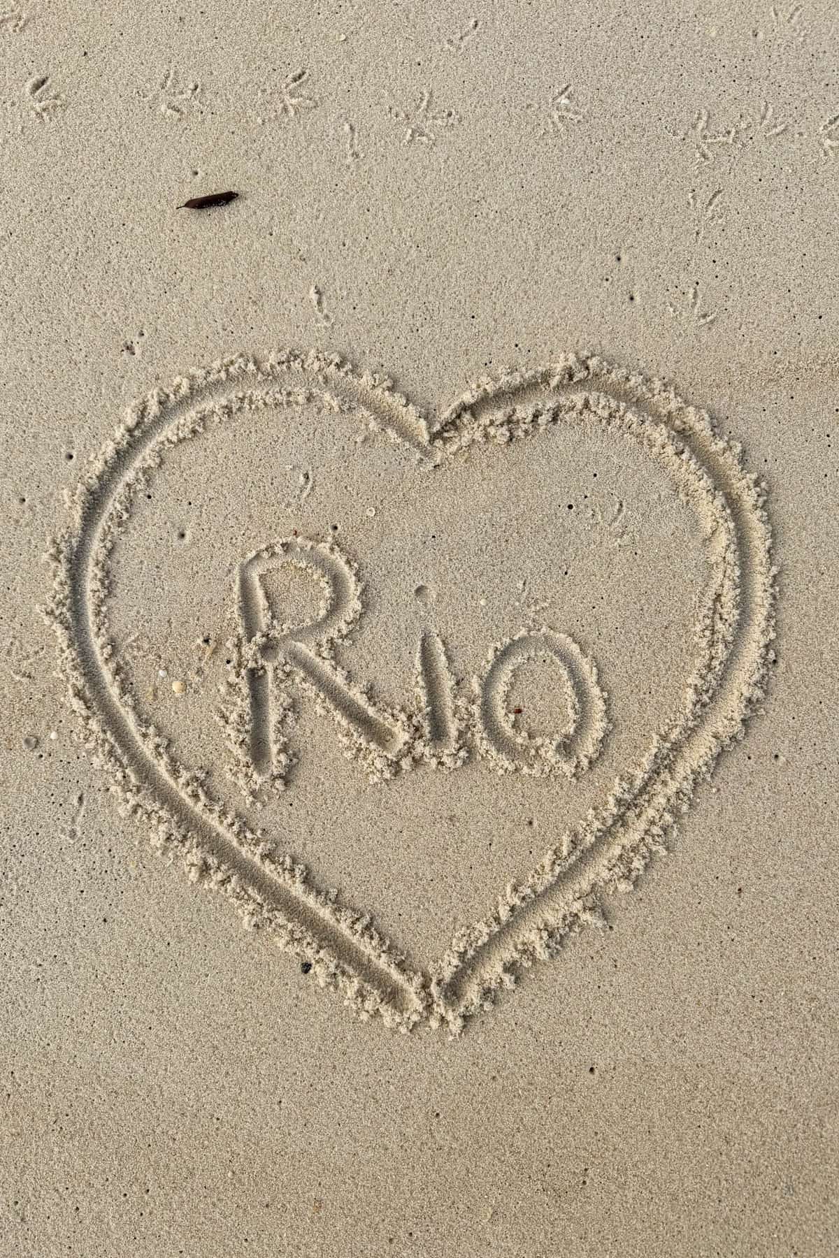 A heart drawn in the sand with the word "Rio" in the center.