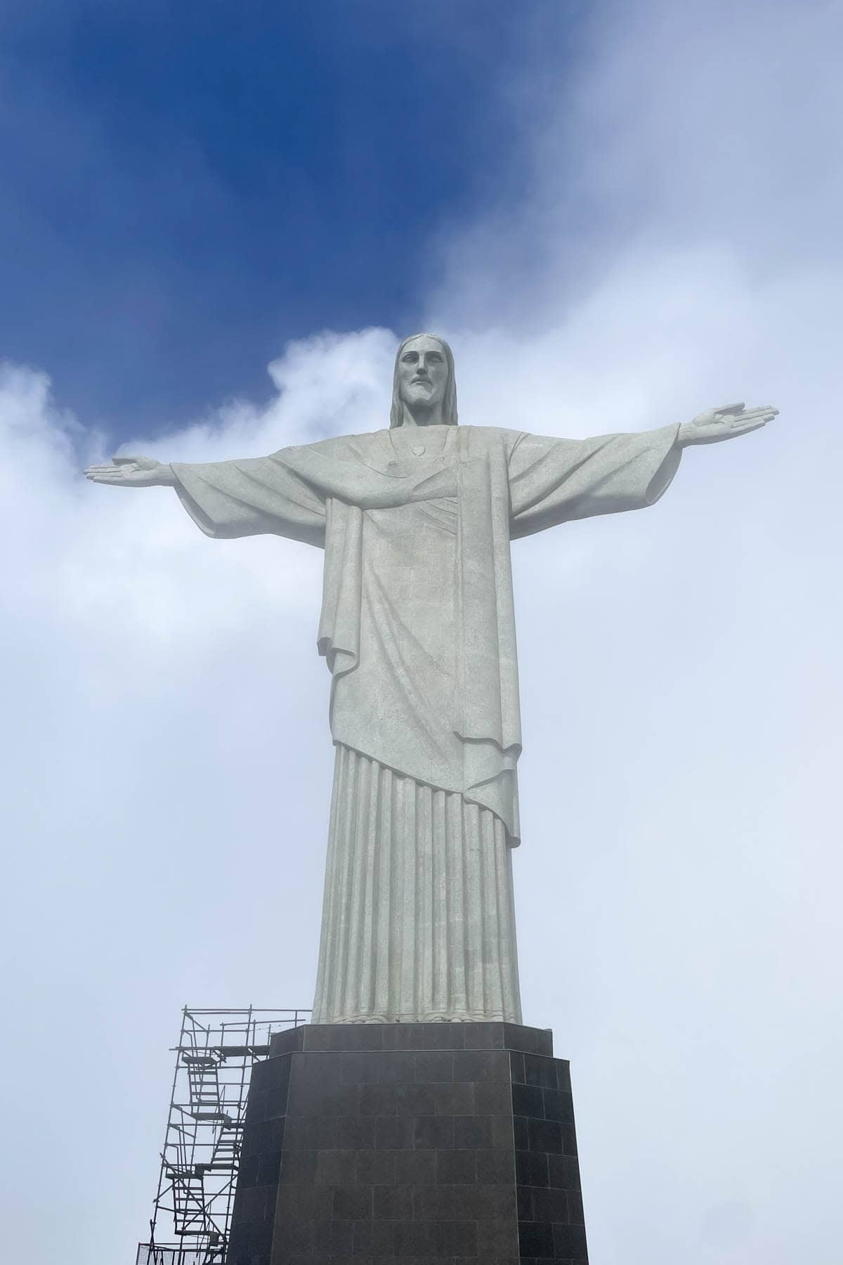 The Christ the Redeemer statue in Rio de Janeiro with blue sky behind it.