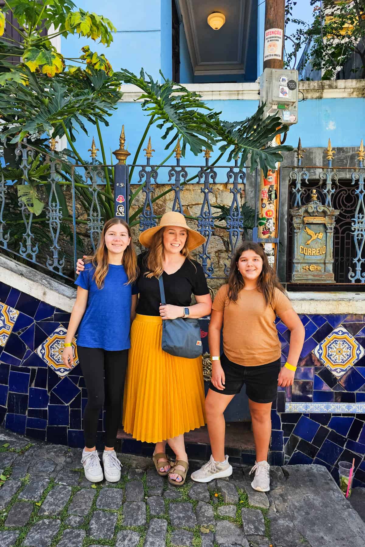 A mom and her daughters in front of colorful walls in Rio de Janeiro.