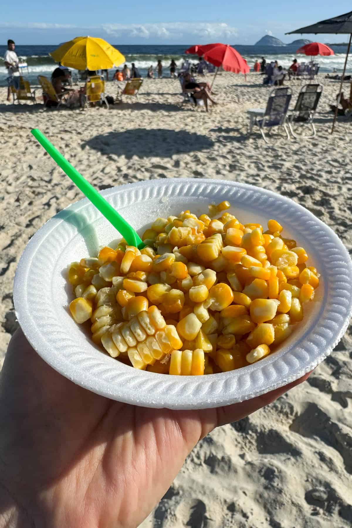 Buttered corn in a bowl on the beach in Rio de Janeiro.