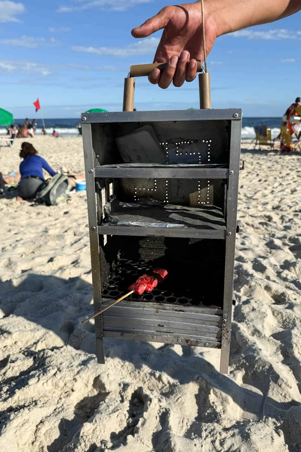 A meat stick in a charcoal grill on the beach in Rio de Janeiro.