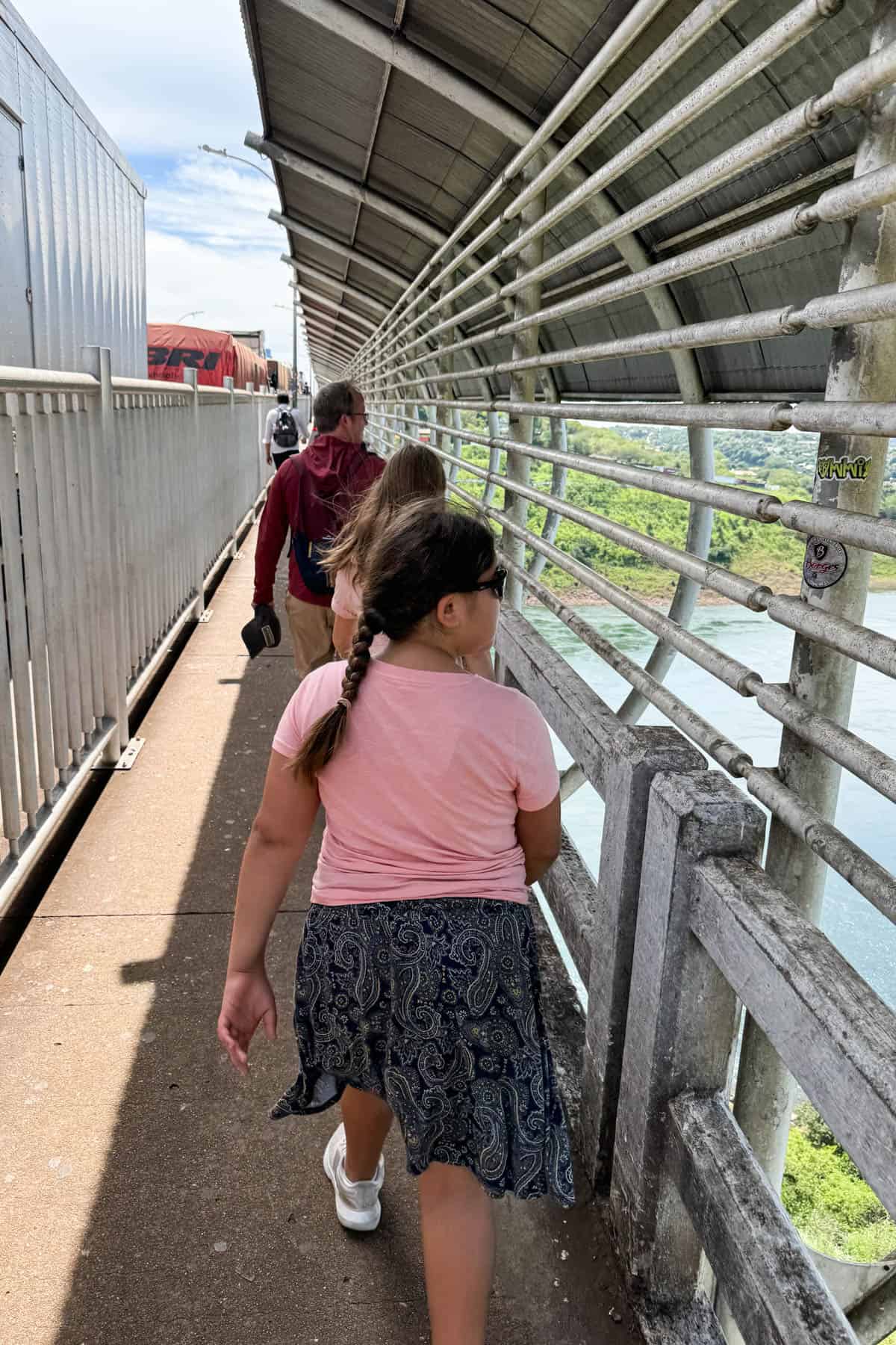 A family walking across the Friendship bridge from Brazil to Paraguay.
