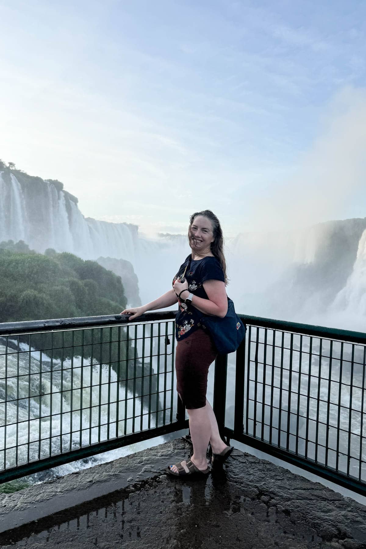 A woman standing by herself at Iguazu Falls in Brazil.