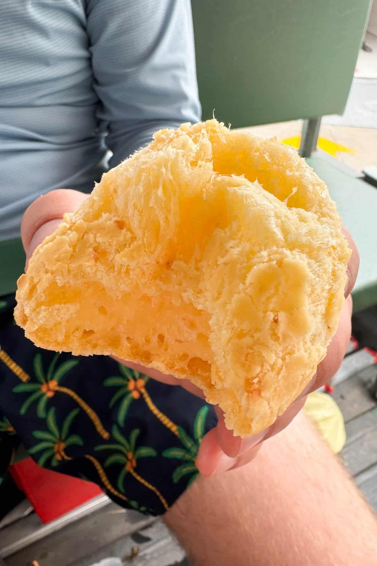 Brazilian cheese bread with a bite taken out of it.