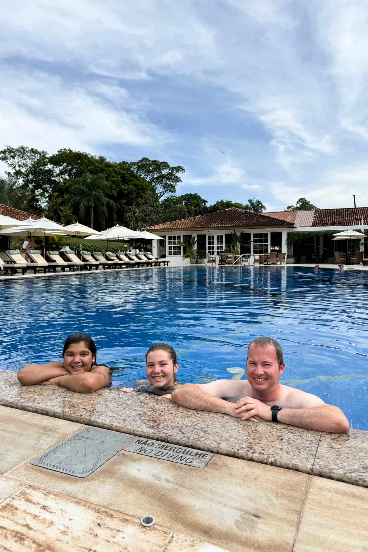 A dad and two daughters at the pool at Hotel das Cataras in Brazil.