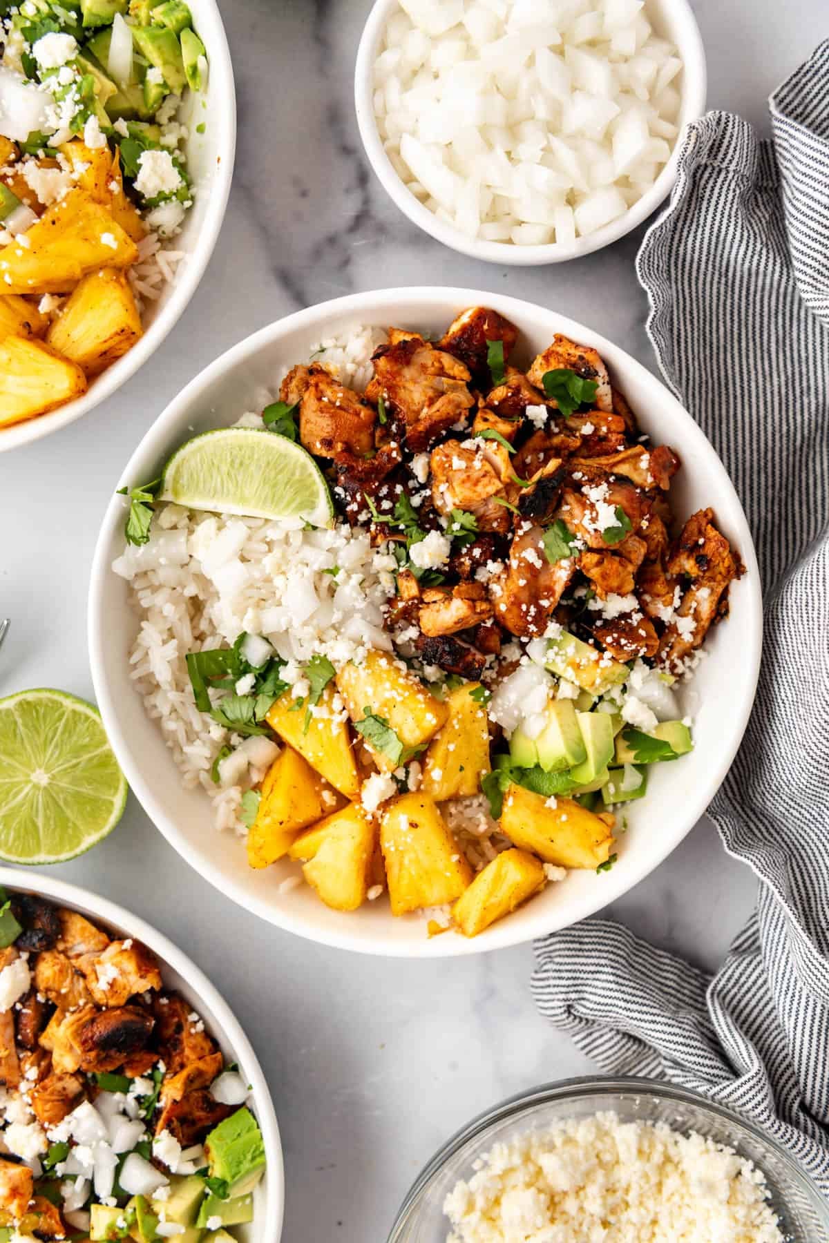 An image of chicken al pastor bowls with chopped chicken, rice, diced avocado, and diced pineapple.