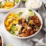 An image of chicken al pastor bowls with chopped chicken, rice, diced avocado, and diced pineapple.