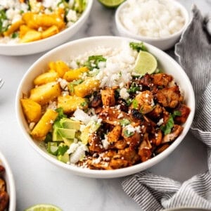 An image of chicken al pastor bowls with chopped chicken, rice, diced avocado, and diced pineapple.