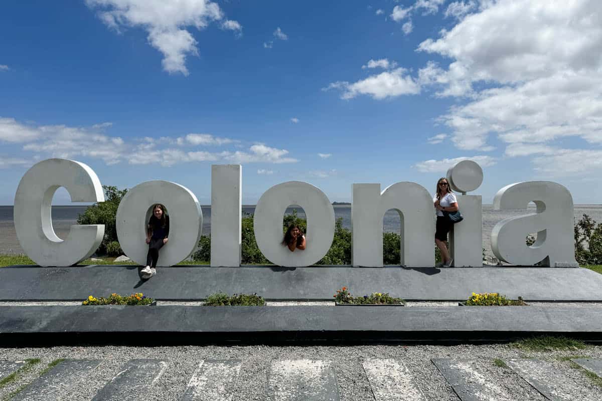 A mom and kids posed in the Colonia sign in Uruguay.