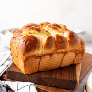 An image of loaves of homemade brioche bread on wooden cutting boards.