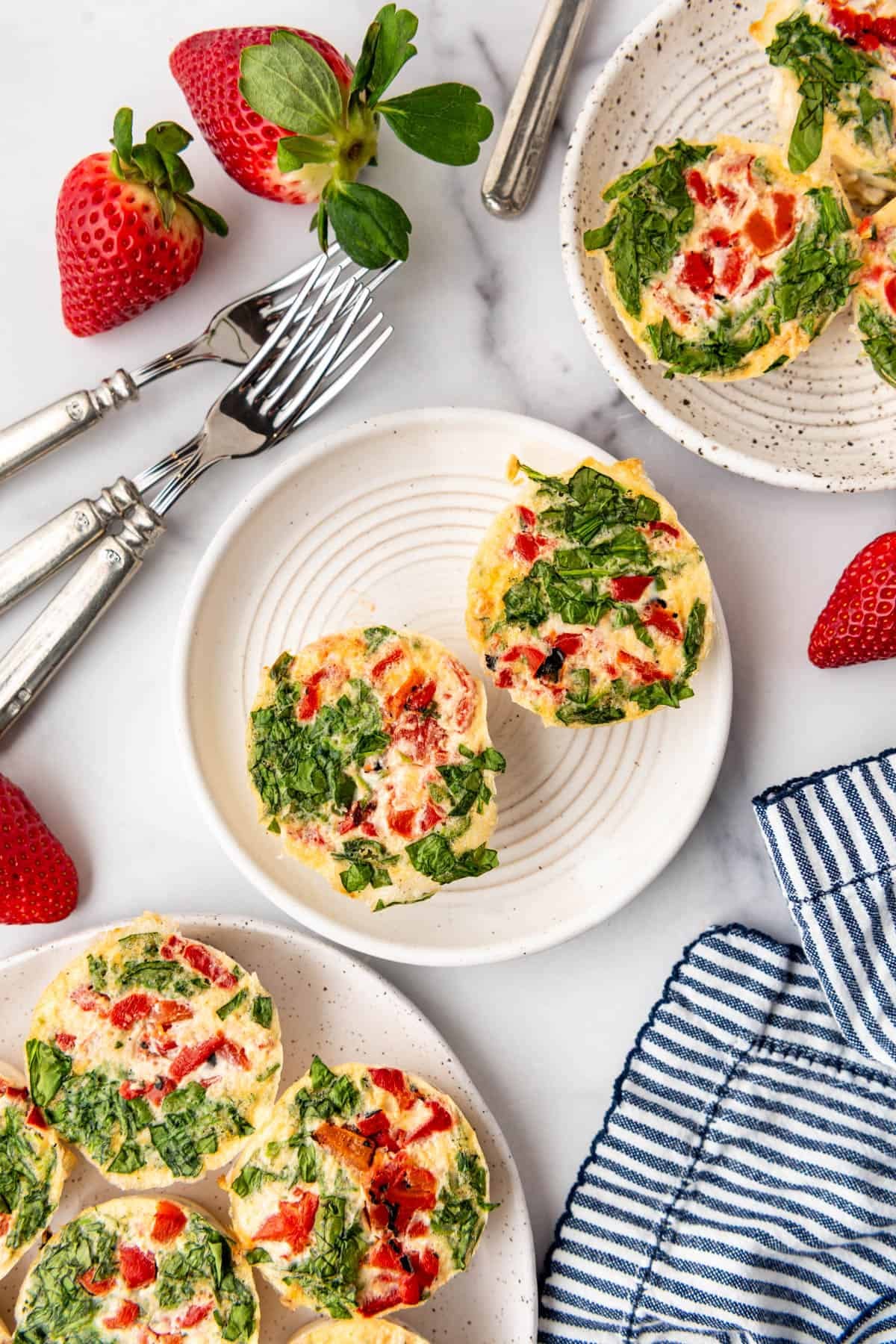 Two egg white bites on a plate surrounded by more bites.