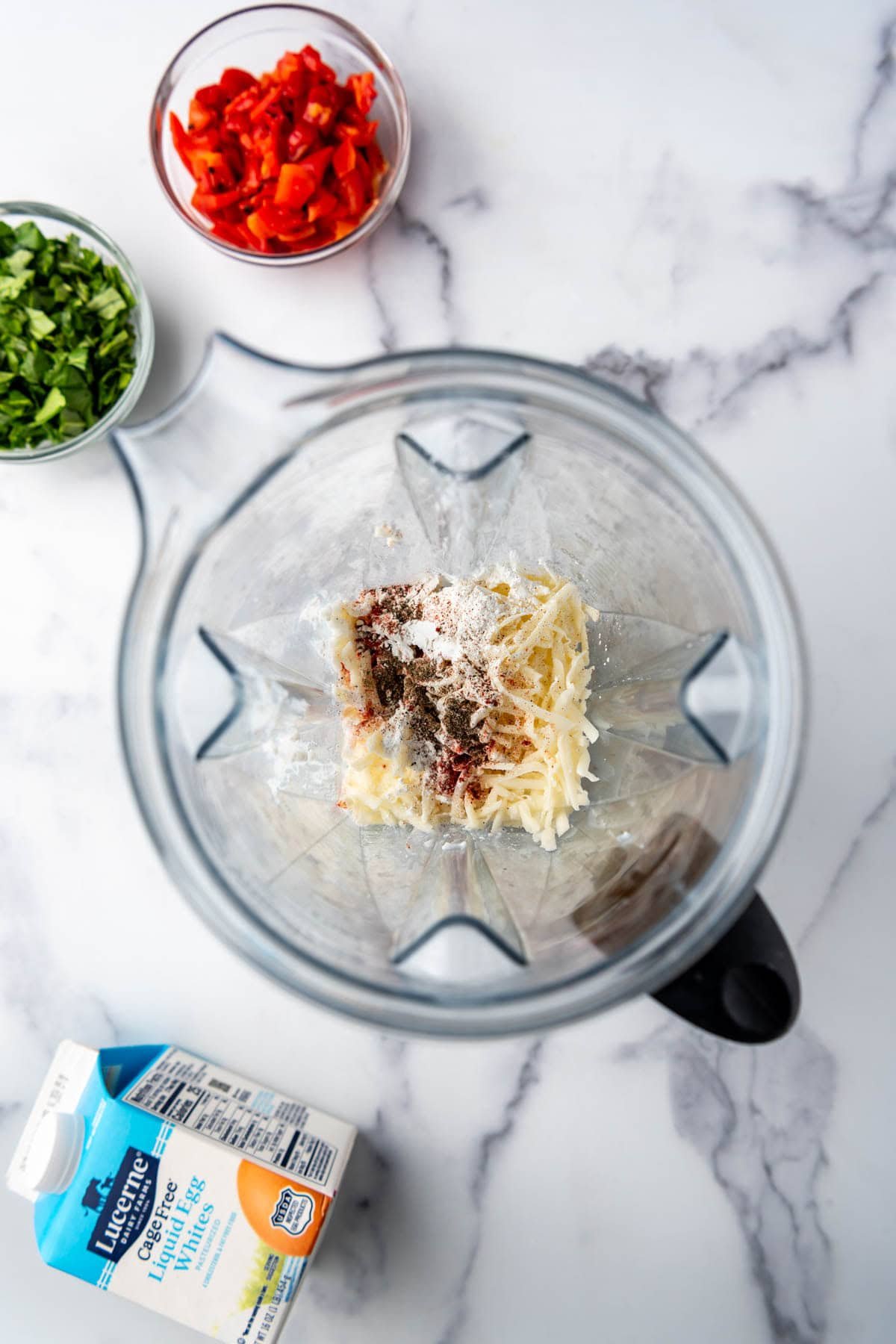 Combining grated cheese and spices in a blender.