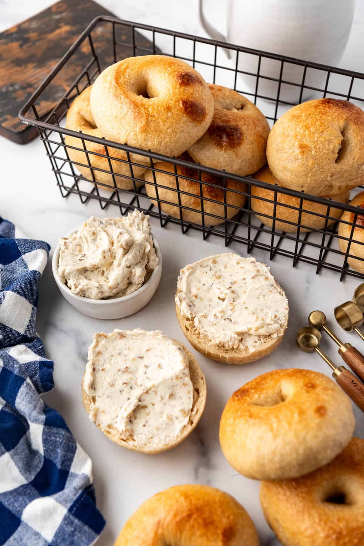 An image of bagels around another bagel that has been split in half and spread with honey walnut cream cheese.