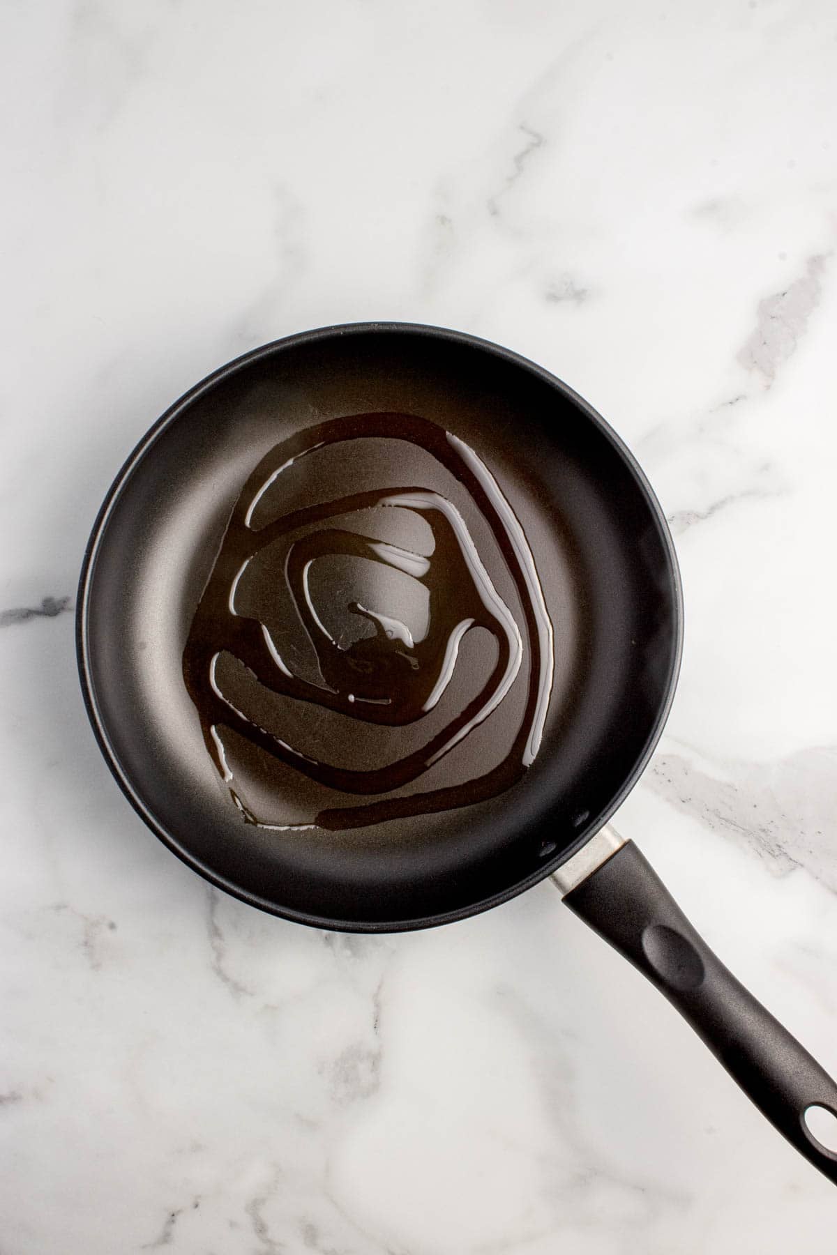 Adding a little oil to a nonstick pan.