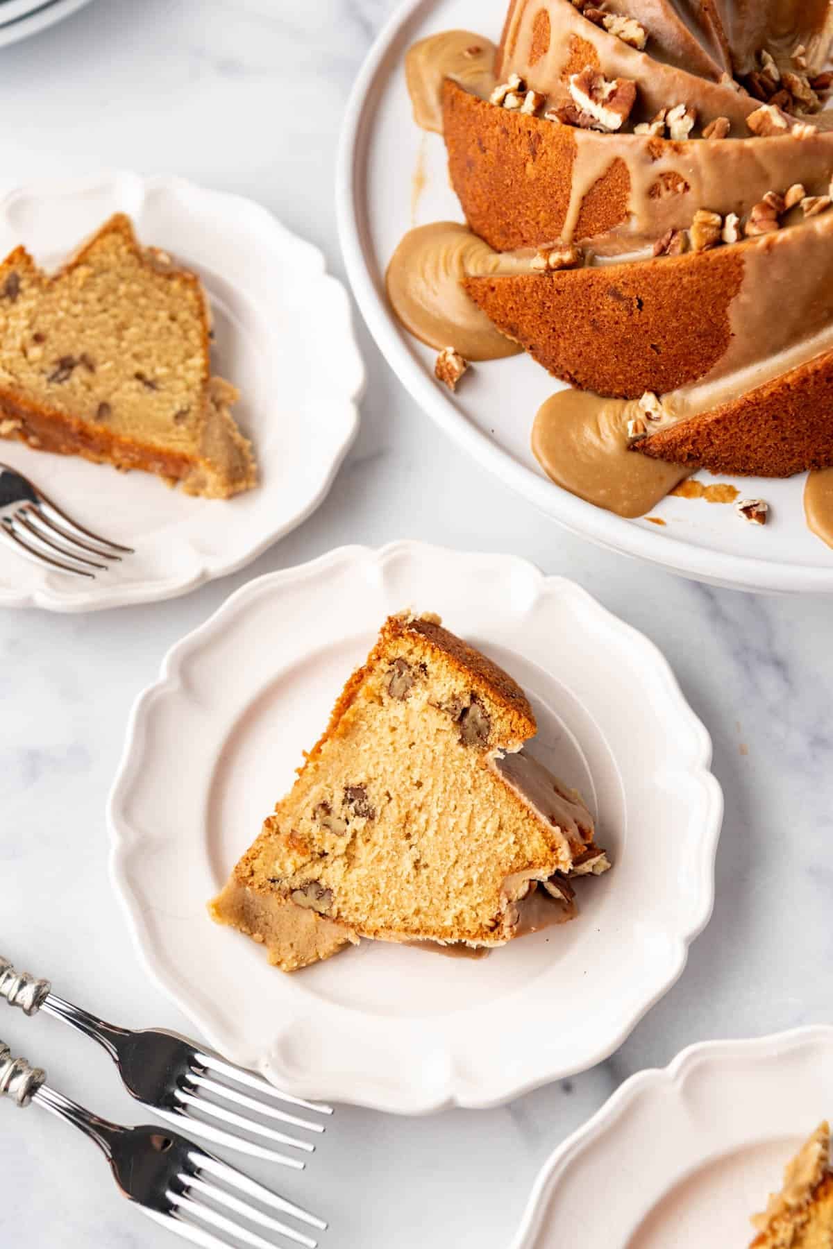 Slices of pecan praline bundt cake on white plates.