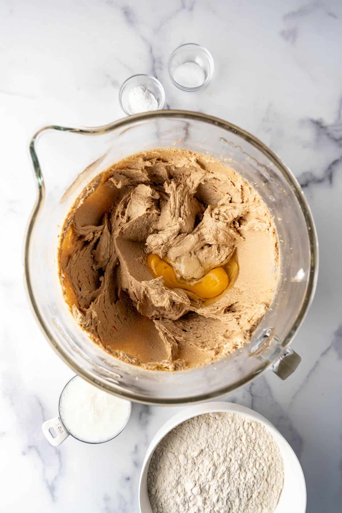 Adding eggs and vanilla to creamed butter and brown sugar in a large mixing bowl.