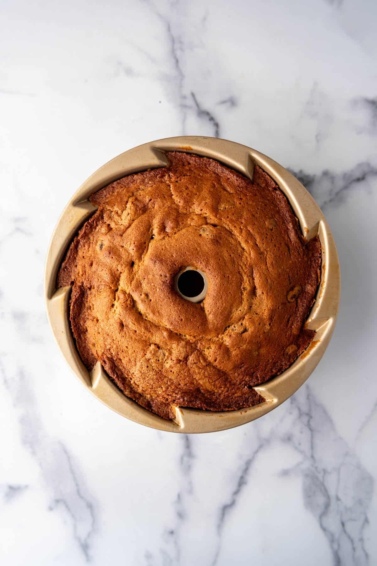 A baked bundt cake in a pan before unmolding.