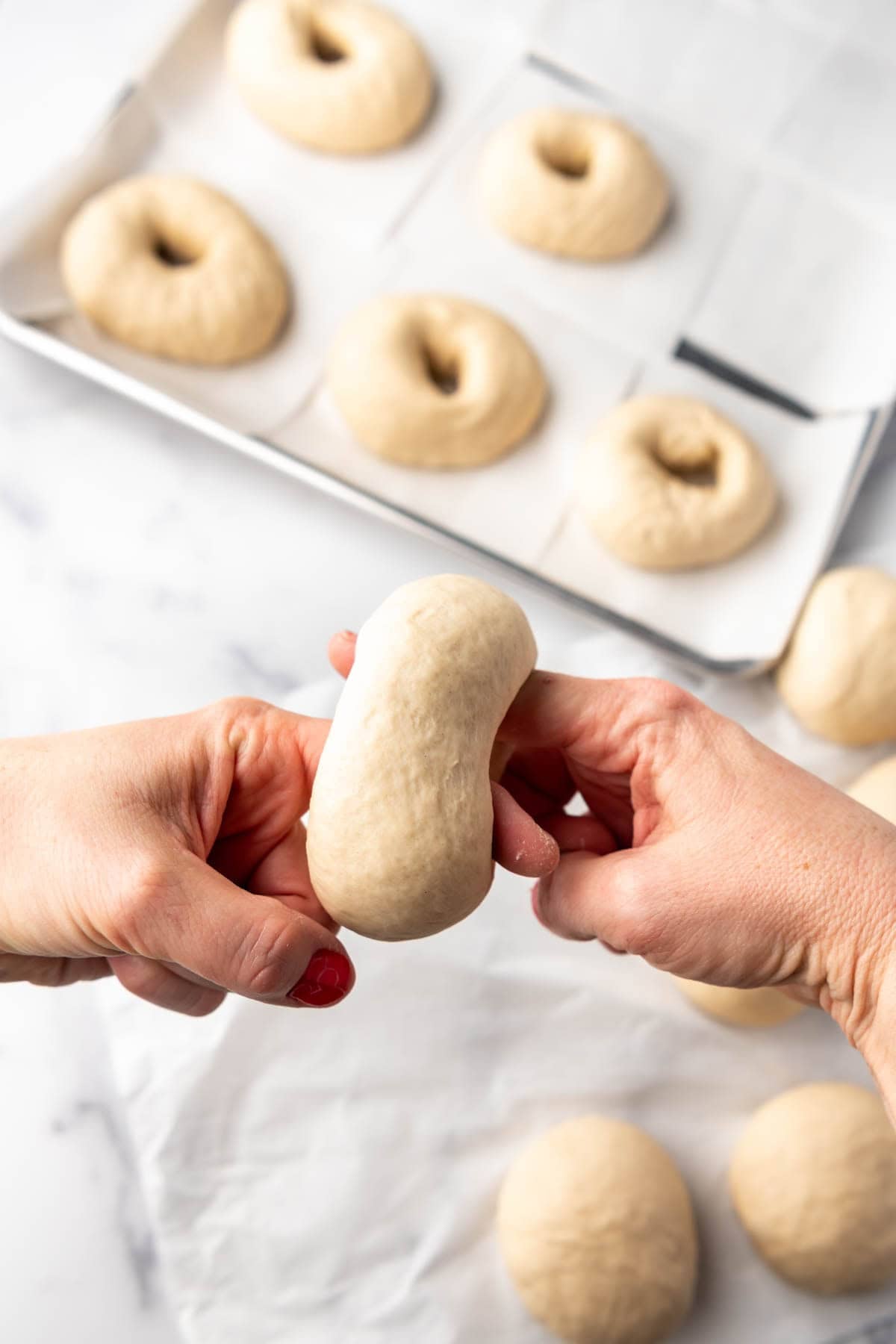 Shaping dough into bagels.