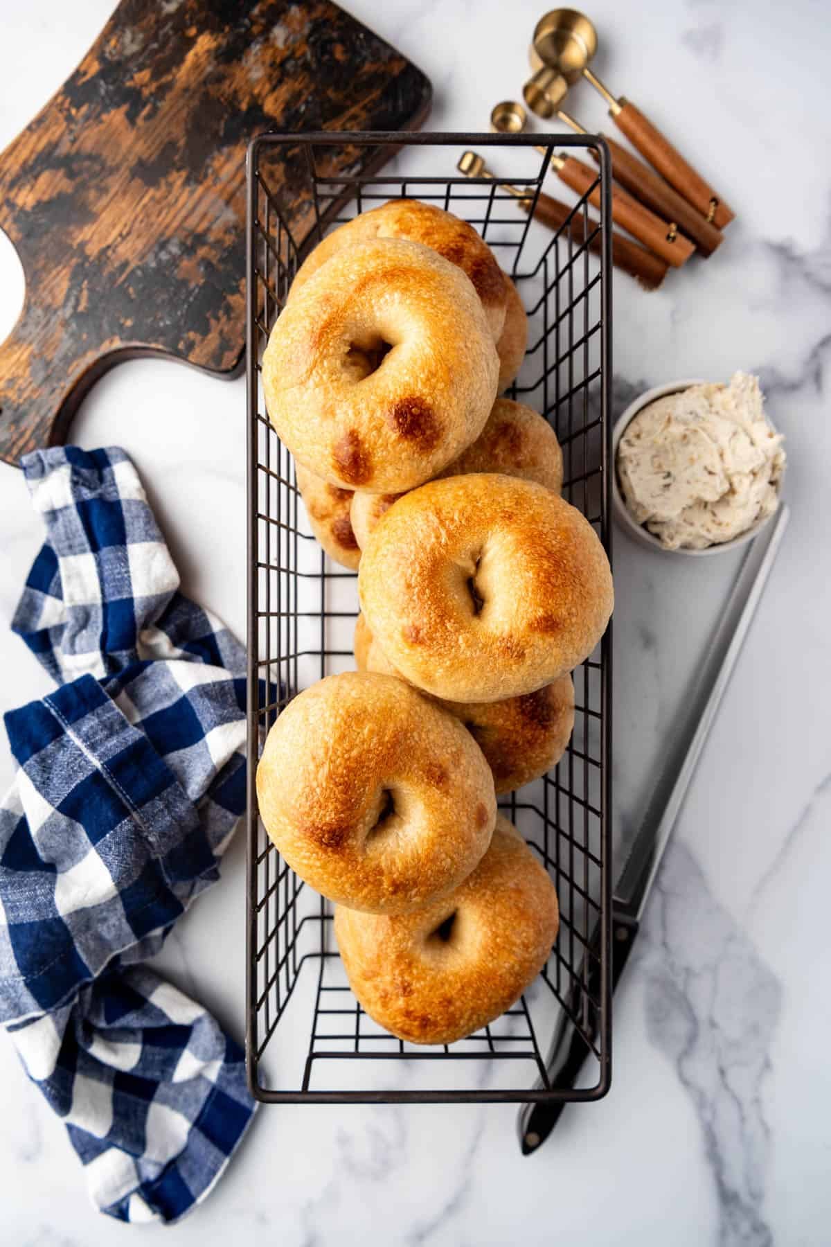 An overhead image of homemade sourdough bagels in a wire basket.