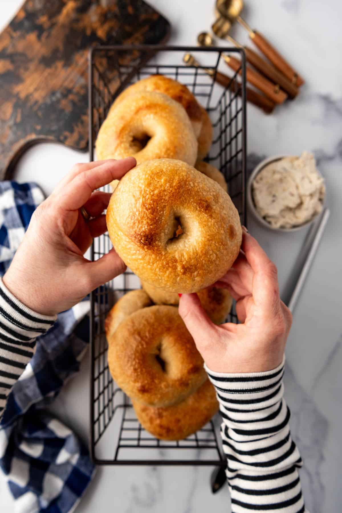 An overhead image of hands holding a sourdough bagel.