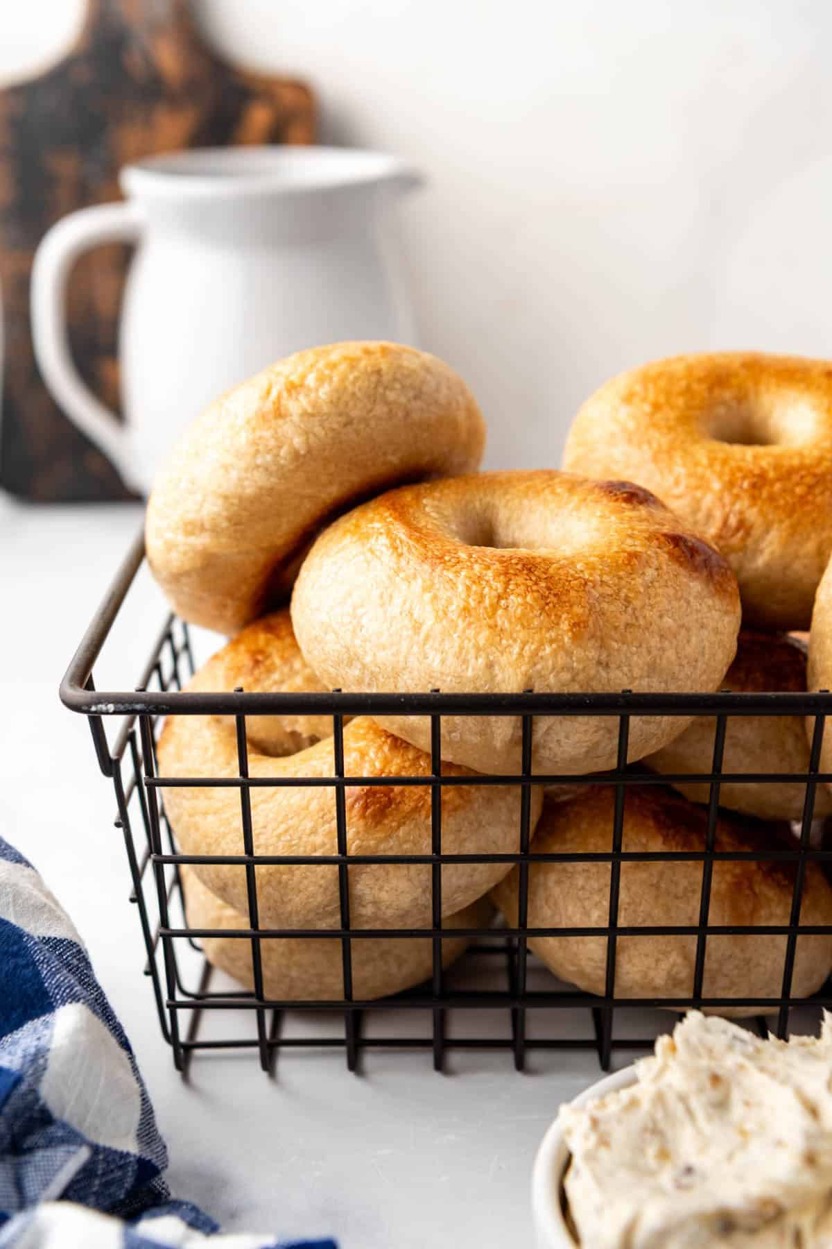 An image of sourdough bagels in a wire basket.
