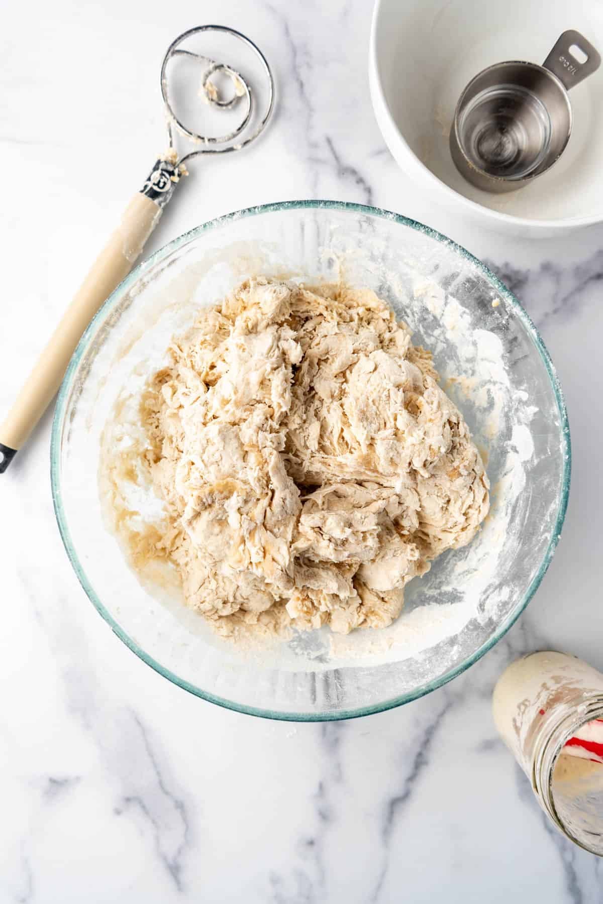 A shaggy sourdough bagel dough in a bowl.