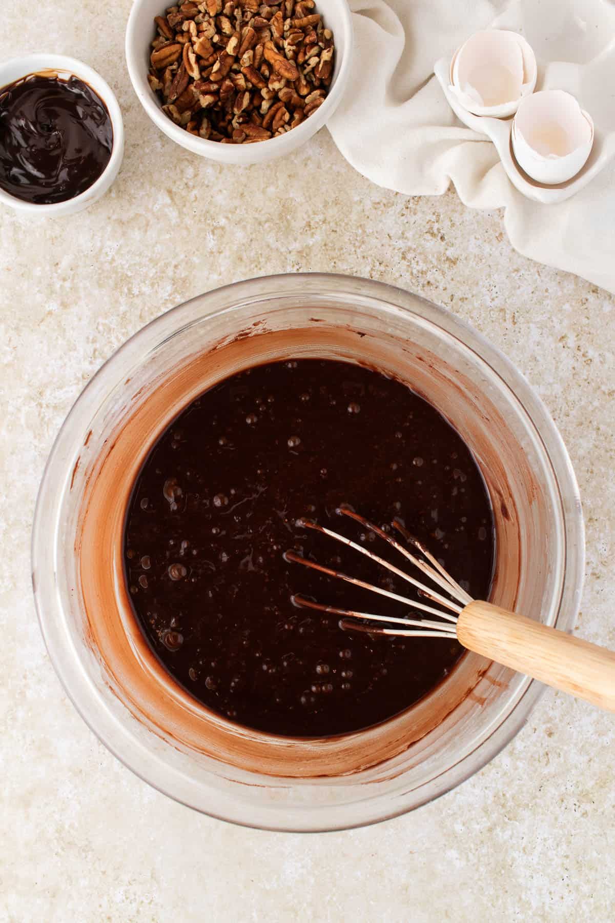 Whisked chocolate cake batter in a glass mixing bowl.