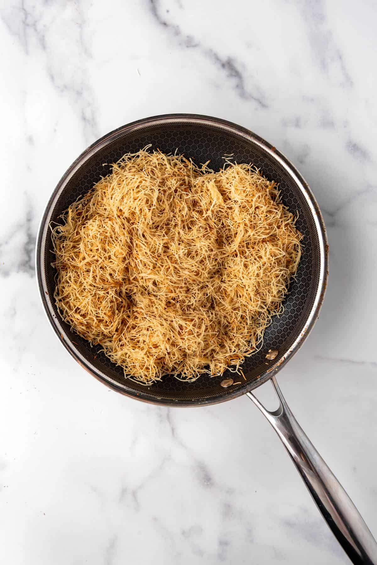 Toasted kataifi in a pan.