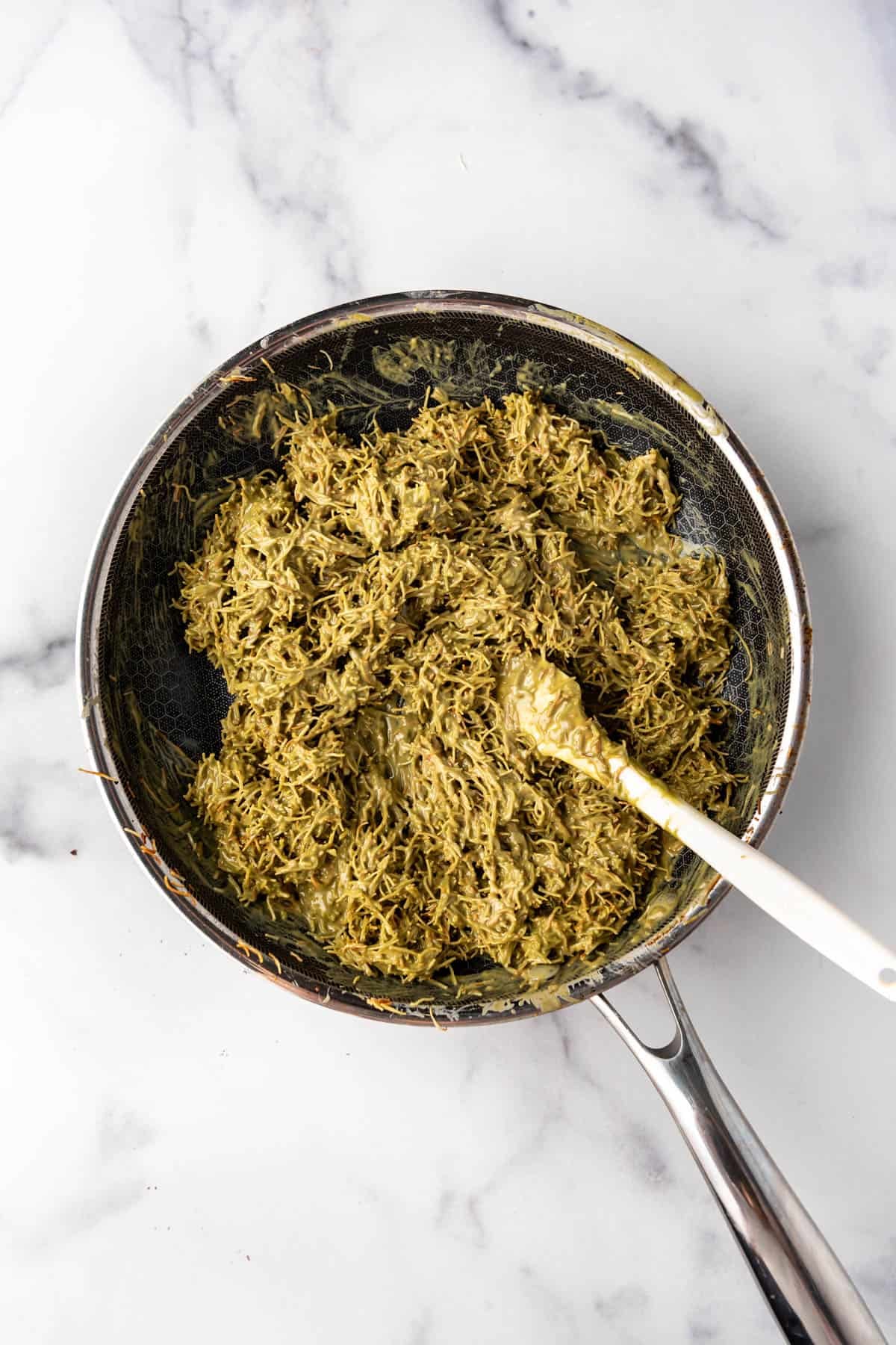 Dubai pistachio filling in a pan with a spatula.