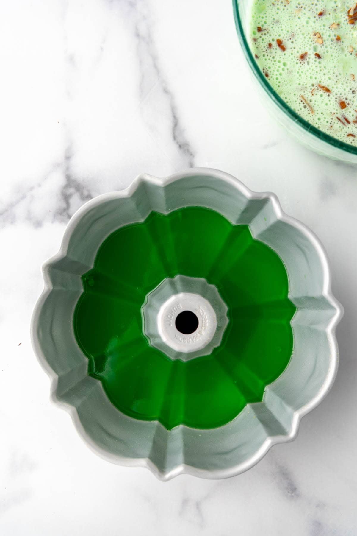 An overhead image of a layer of plain lime jell-o in a jello mold.