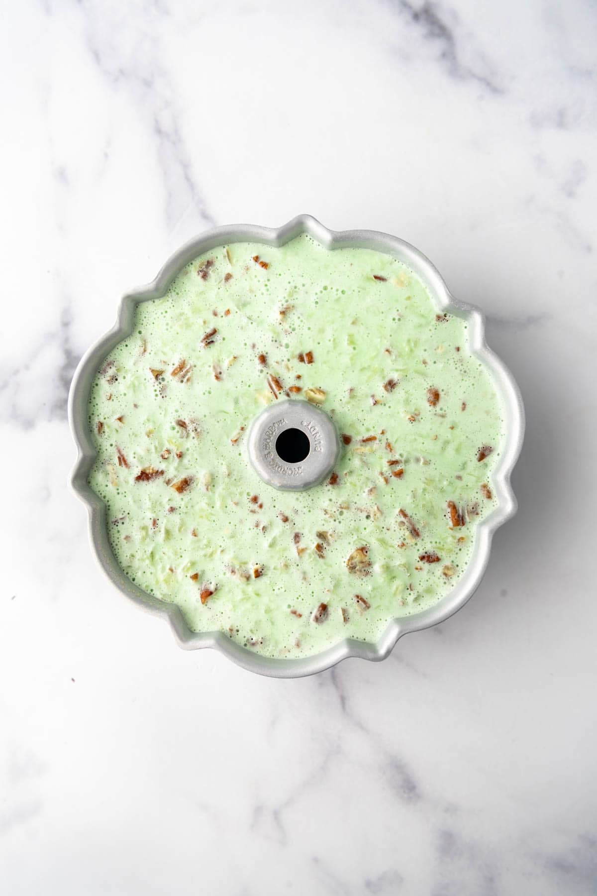 A bundt pan jallo mold holding a creamy lime jello.
