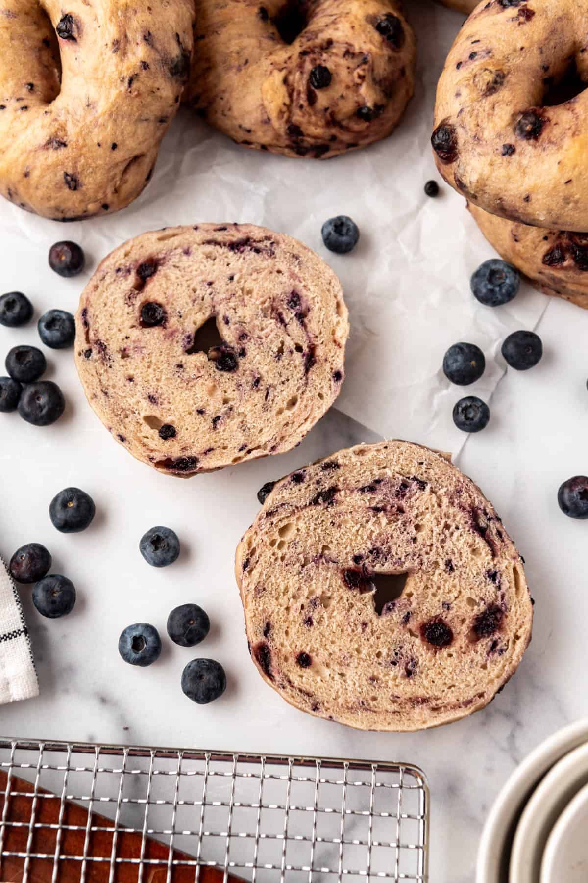 A homemade blueberry bagel that has been sliced in half horizontally for toasting.